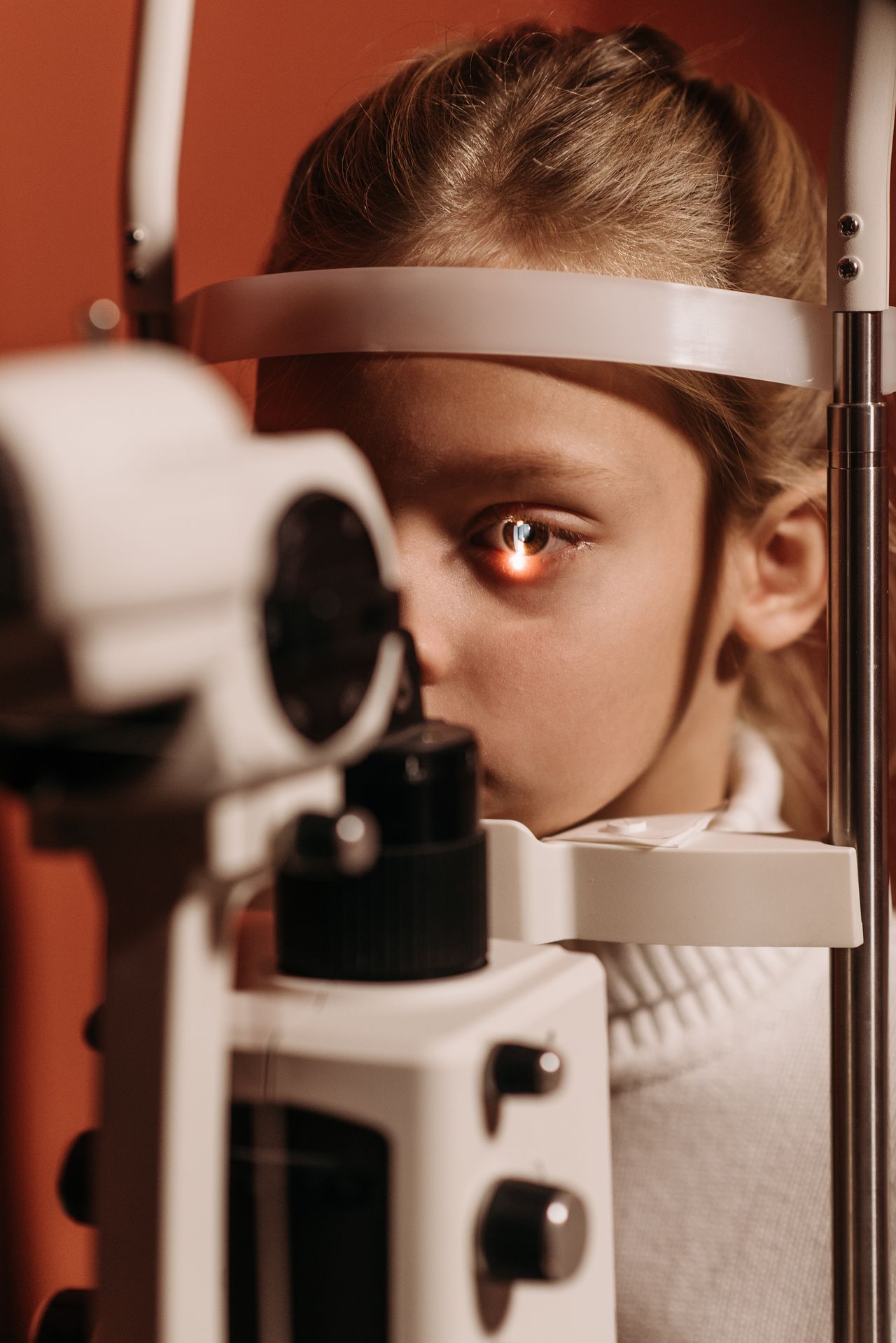Optician checking eye pressure during home visit