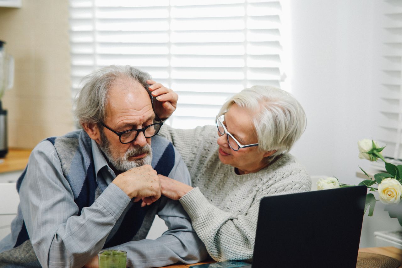 Family carer supporting elderly patient at home eye test