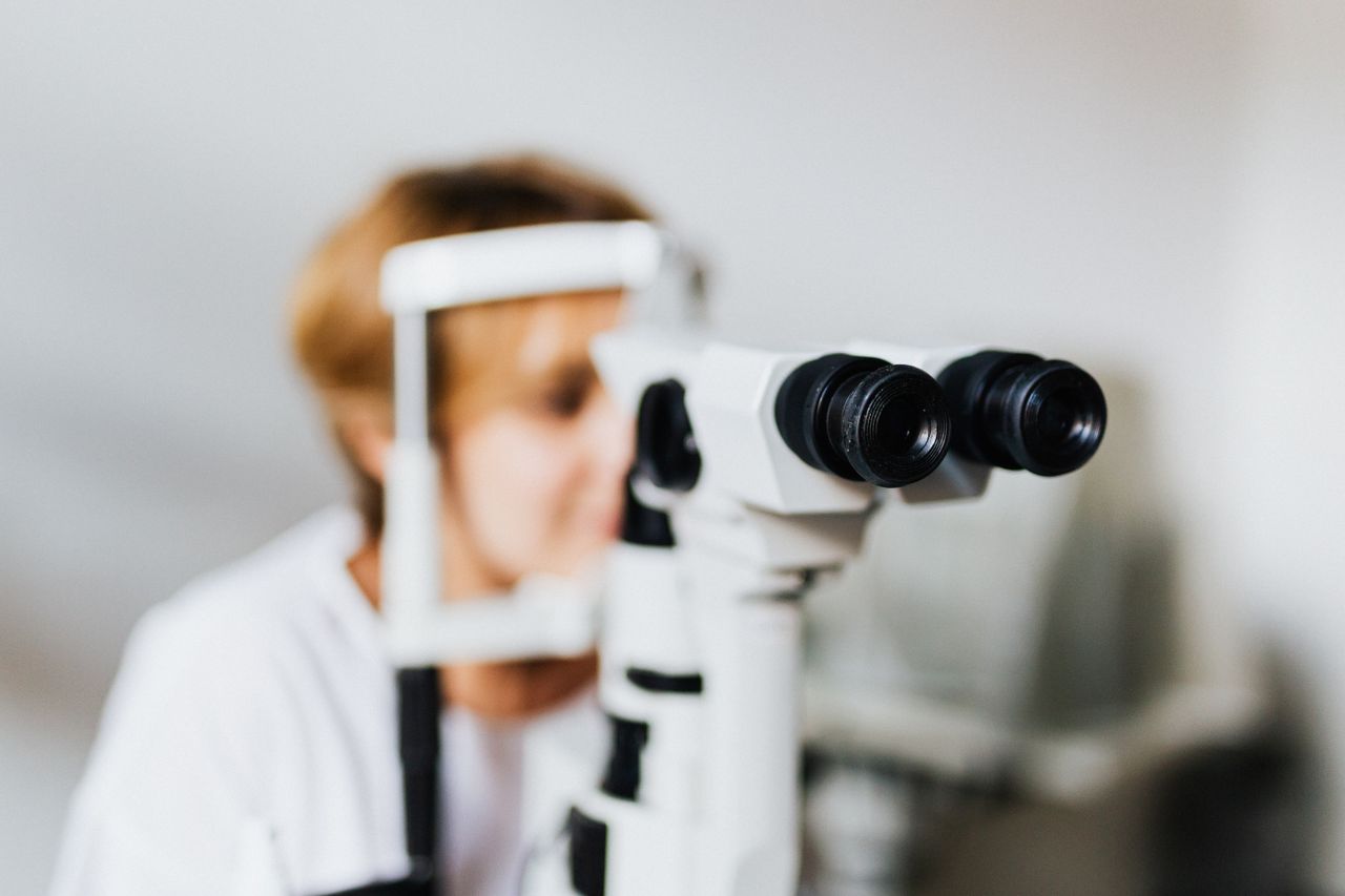 Elderly person with magnifying glass due to macular degeneration