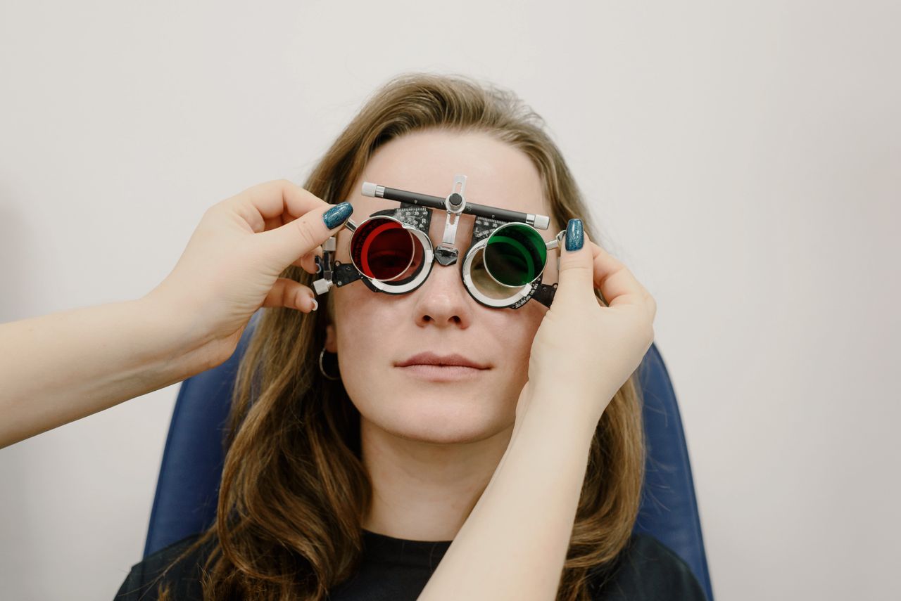 Optician carrying out NHS home eye test with elderly patient