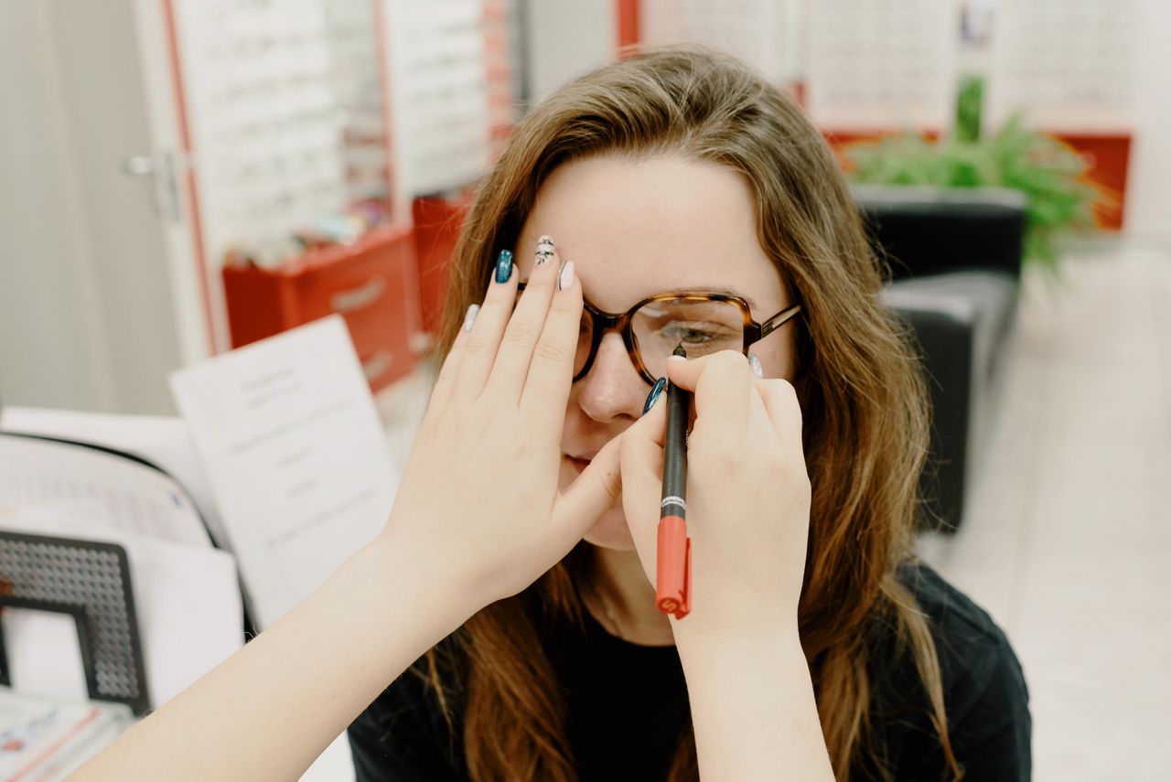 Optician discussing ongoing eye care with elderly patient and family member